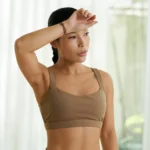Woman wiping forehead after sweating, illustrating hyperhidrosis and treatment options at Natural Beauty Clinic White Rock